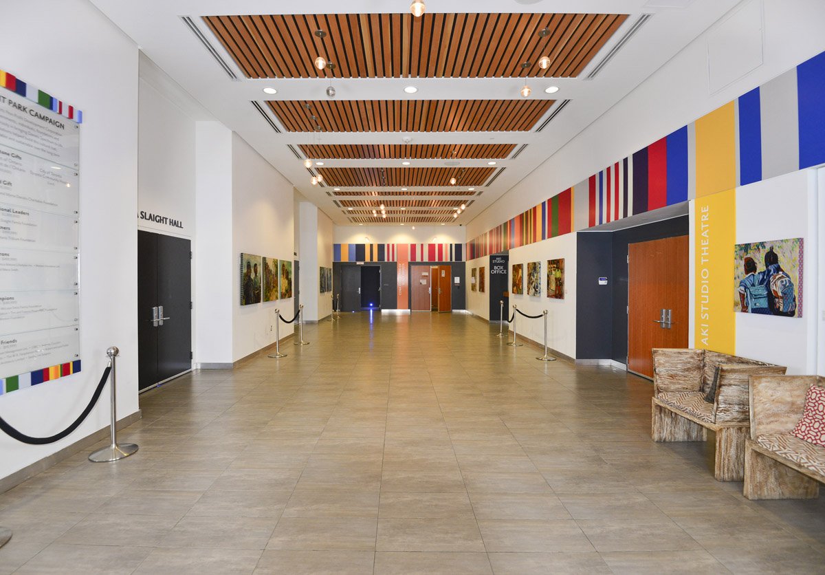 Daniels Spectrum lobby — gallery corridor with art and warm wood ceiling